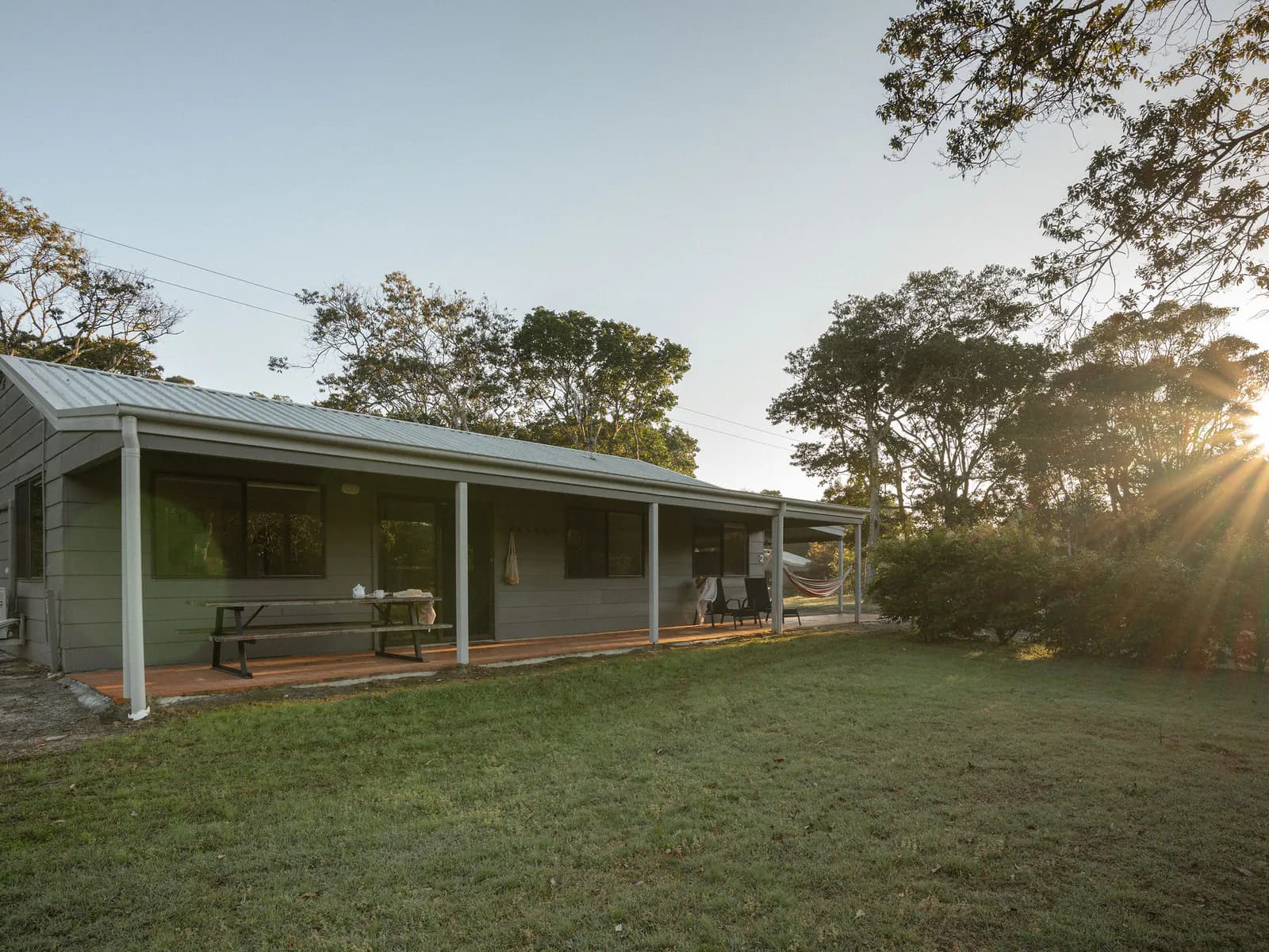 A Big Hill Beach cottage and its verandah on the lawns at sunset